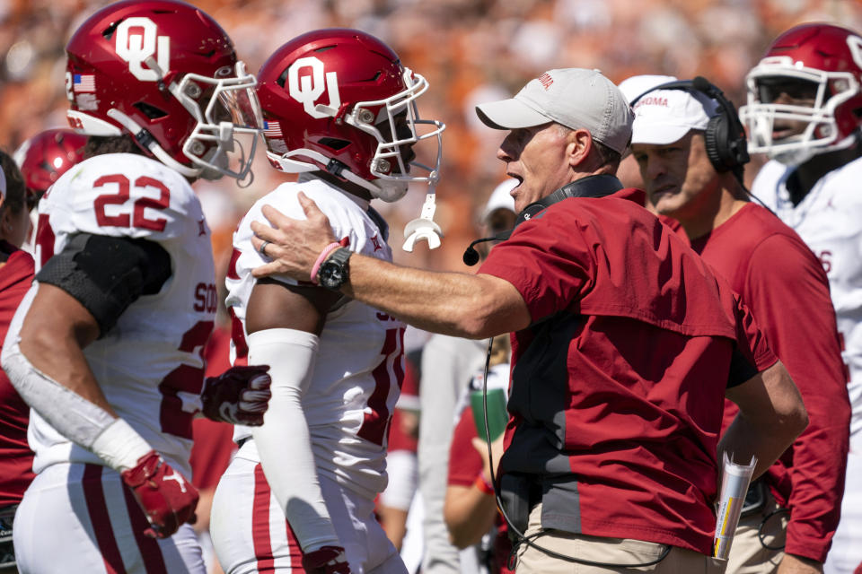 Oklahoma head coach Brent Venables talks on the sidelines with Oklahoma defensive back Kendel Dolby (15) during the first half of an NCAA college football game against Texas at the Cotton Bowl, Saturday, Oct. 7, 2023, in Dallas. (AP Photo/Jeffrey McWhorter)