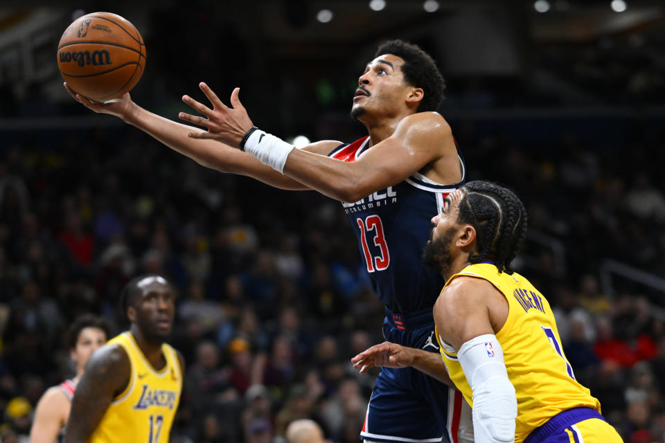 Washington Wizards guard Jordan Poole scores against Los Angeles Lakers guard Gabe Vincent during the first half of an NBA basketball game Wednesday, April 3, 2024, in Washington. (AP Photo/John McDonnell)