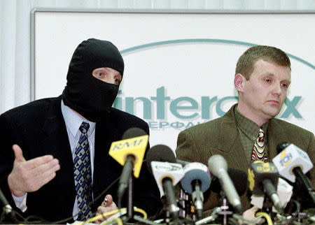 Alexander Litvinenko (R), listens as a masked colleague speaks during a news conference in Moscow in November 17, 1998. REUTERS/Sergei Kaptilkin