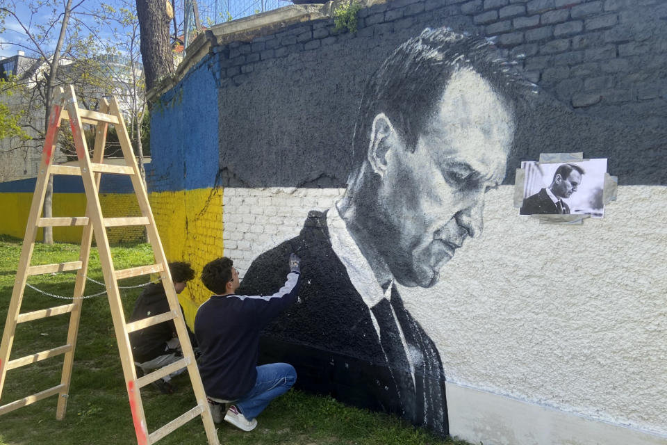 Austrian graffiti duo Joel Gamnou paint a picture of Alexei Navalny on a wall in Vienna, Austria, Wednesday, March 27, 2024. Two large portraits of the late Russian opposition leader Alexei Navalny have been spray-prainted on a property owned by the family of a former Czech foreign minister behind a monument to Soviet soldiers in Vienna. (AP Photo/Philipp-Moritz Jenne)