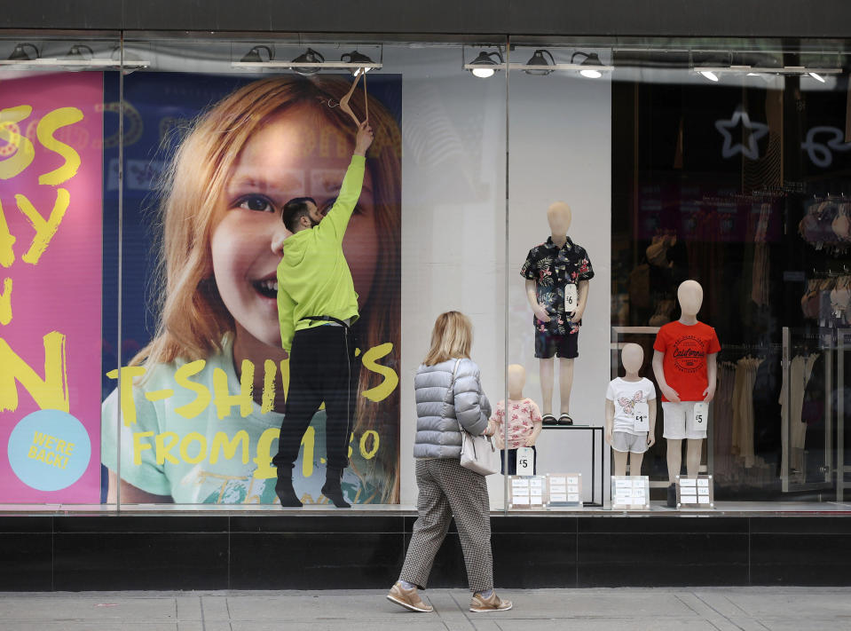 Final touches are made to a window display in a Primark store on Oxford Street, central London, Sunday April 11, 2021. Millions of people in Britain will get their first chance in months for haircuts, casual shopping and restaurant meals on Monday, as the government takes the next step on its lockdown-lifting roadmap. (Yui Mok/PA via AP)