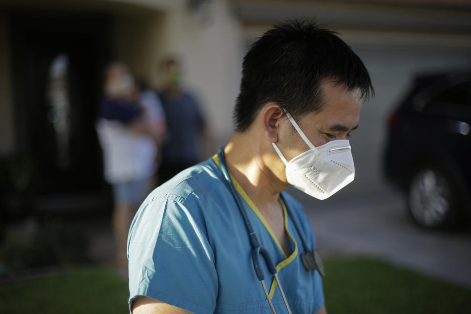 Dr. Tien Vo goes to leave after talking with a family quarantining after they tested positive for the coronavirus Thursday, July 23, 2020, in Calexico, Calif. Vo and members of his clinic bring food to patients that test positive and agree to quarantine. (AP Photo/Gregory Bull)