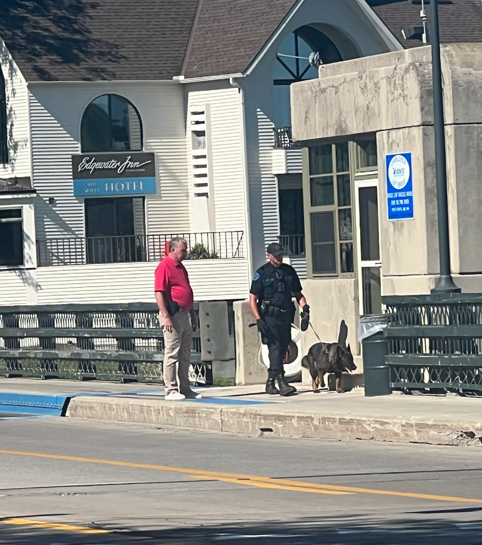 Charlevoix Police Chief Gerard Doan (left) and a K9 unit search the bascule bridge in Charlevoix on Thursday after a bomb threat.