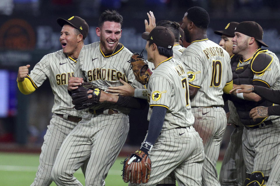 San Diego Padres starting pitcher Joe Musgrove, second from left, is mobbed by teammates after pitching a no-hitter against the Texas Rangers in a baseball game Friday, April 9, 2021, in Arlington, Texas. (AP Photo/Richard W. Rodriguez)