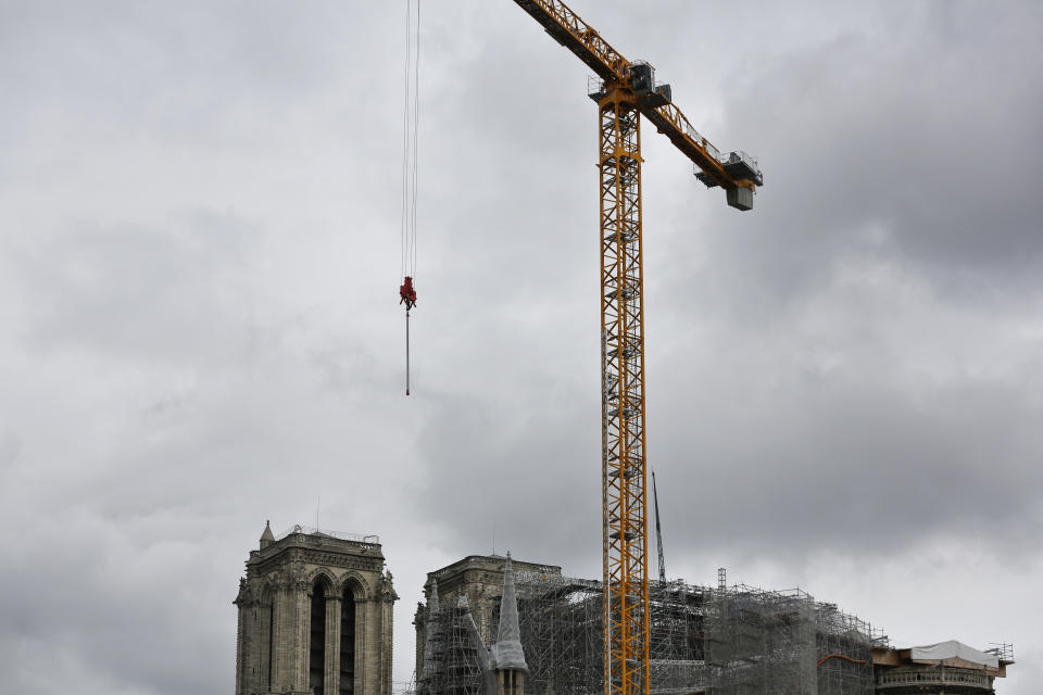 A crane stands by Notre Dame Cathedral, Friday, July 10, 2020 in Paris. Notre Dame Cathedral will be rebuilt just the way it stood before last year's devastating fire. (AP Photo/Thibault Camus)