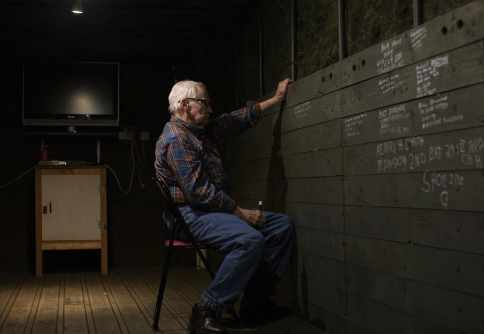 In this Tuesday, Dec. 10, 2019 photo, World War II and Battle of the Bulge veteran Arthur Jacobson, from Port St. Lucie, Florida, writes his name and unit name inside the back of a World War II vehicle at the Remember Museum 39-45 in Thimister-Clermont, Belgium. It was 75 years ago that Hitler launched his last desperate attack to turn the tide for Germany in World War II. At first, German forces drove so deep through the front line in Belgium and Luxembourg that the month-long fighting came to be known as The Battle of the Bulge. (AP Photo/Virginia Mayo)