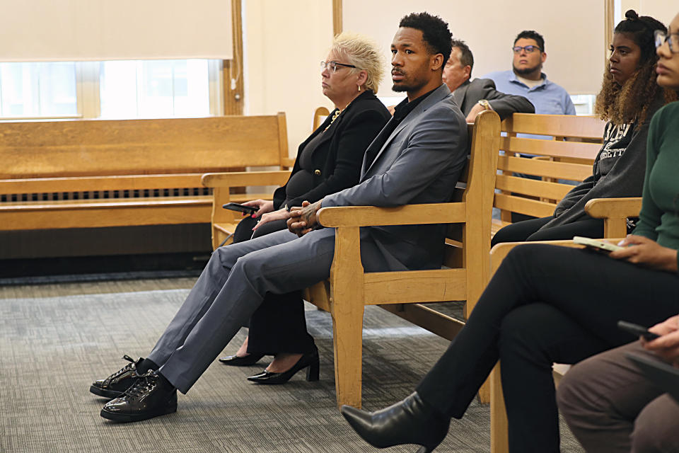 New England Patriots cornerback Jack Jones, center, is seated at his arraignment on gun charges at East Boston Municipal Court, Tuesday, June 20, 2023, in Boston, Mass. Jones was charged with carrying two loaded guns in his carry-on luggage at Logan Airport. (Suzanne Kreiter/The Boston Globe via AP, Pool)