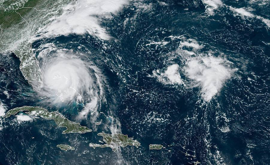 This GOES-16 satellite image taken Monday, Sept. 2, 2019, at 16:40 UTC and provided by National Oceanic and Atmospheric Administration (NOAA), shows Hurricane Dorian, left, churning over Bahamas. Hurricane Dorian hovered over the Bahamas on Monday, pummeling the islands with a fearsome Category 4 assault that forced even rescue crews to take shelter until the onslaught passes. (NOAA via AP)