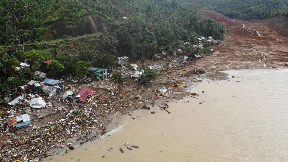 An aerial view shows destroyed houses on a collapsed mountain side along the coastline in the village of Pilar, Abuyog town, Leyte province on April 14, 2022 day after a landslide struck the village due to heavy rains at the height of Tropical Storm Megi. Philippine meteorologists forecast around 10 to 15 tropical cyclones will enter the Philippines in the second half of 2022.  (Photo by BOBBIE ALOTA/AFP via Getty Images)