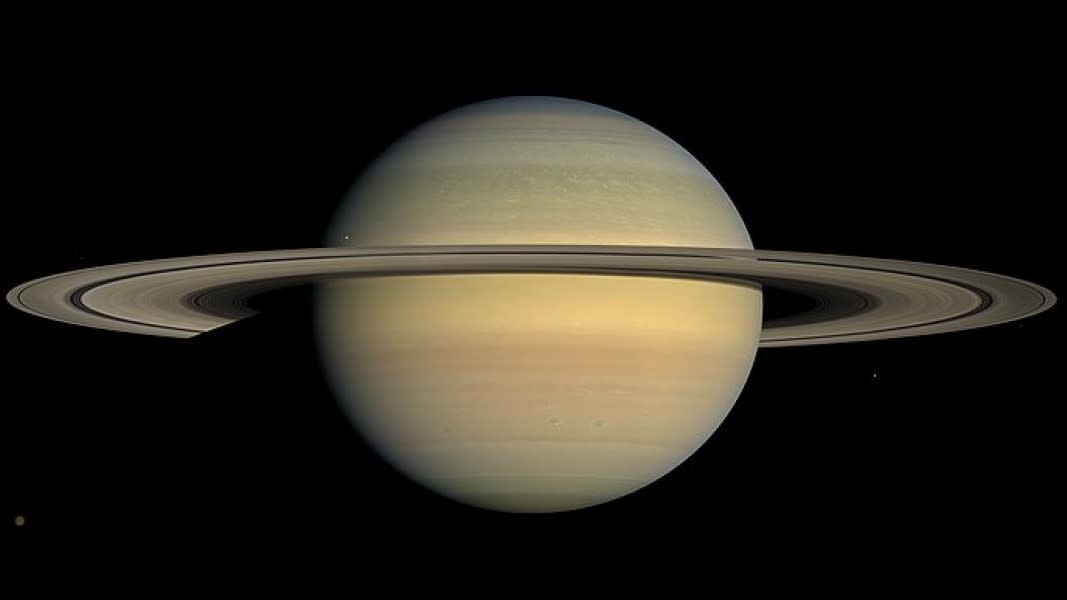  A picture of big, ringed Saturn with several moons orbiting around its edges 