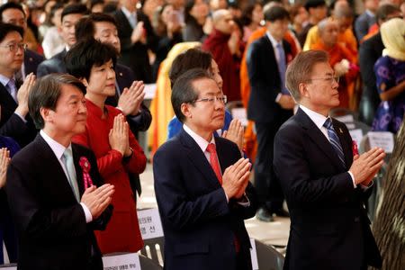 Ahn Cheol-soo, presidential candidate of the People's Party, Hong Joon-pyo, presidential candidate of the Liberty Korea Party, and Moon Jae-in, presidential candidate of the Democratic Party of Korea, attend during a ceremony celebrating the birthday of Buddha at Jogye temple in Seoul, South Korea, May 3, 2017. REUTERS/Kim Hong-Ji