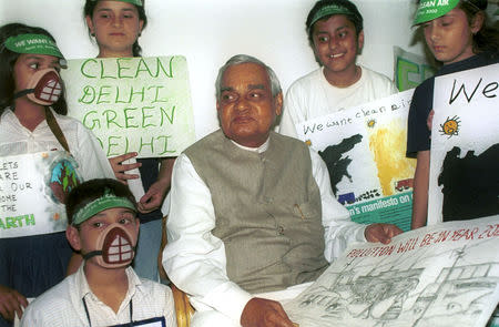 FILE PHOTO: Indian Prime Minister Atal Behari Vajpayee sits with school children, some of them wearing masks to protect from pollution, at his residence on Earth Day in New Delhi, India April 22, 2000. REUTERS/File Photo