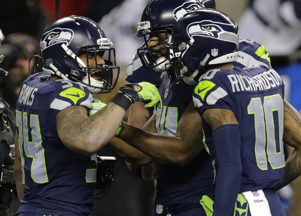 Seattle Seahawks running back Thomas Rawls, left, is greeted by wide receiver Paul Richardson, right, after Rawls scored a touchdown against the Detroit Lions in the second half of an NFL football NFC wild card playoff game, Saturday, Jan. 7, 2017, in Seattle. (AP Photo/Stephen Brashear)