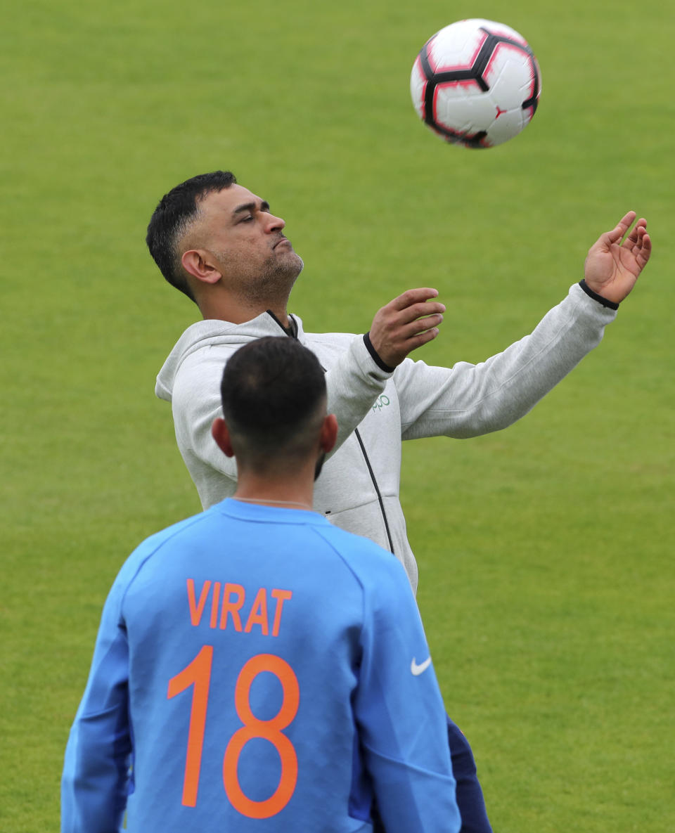 India's captain Virat Kohli, left, and MS Dhoni play with a soccer ball during a training session ahead of their Cricket World Cup match against Afghanistan at the Hampshire Bowl in Southampton, England, Wednesday, June 19, 2019. (AP Photo/Aijaz Rahi)