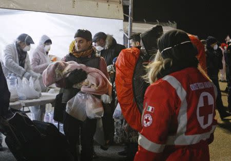 Medics help migrants after they disembarked from the Sierra Leone-flagged vessel Ezadeen at the Corigliano Calabro harbor southern Italy January 3, 2015. REUTERS/Antonino Condorelli