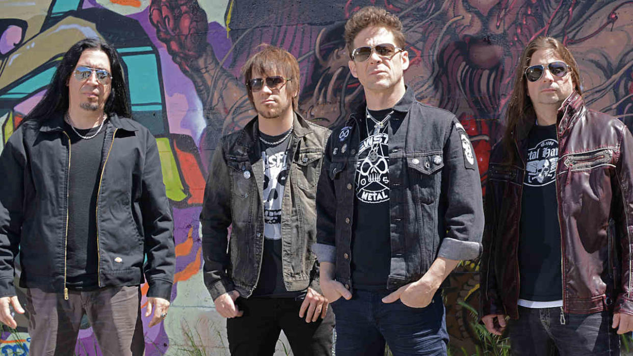  Jason Newsted and his band in front of a graffiti covered wall. 