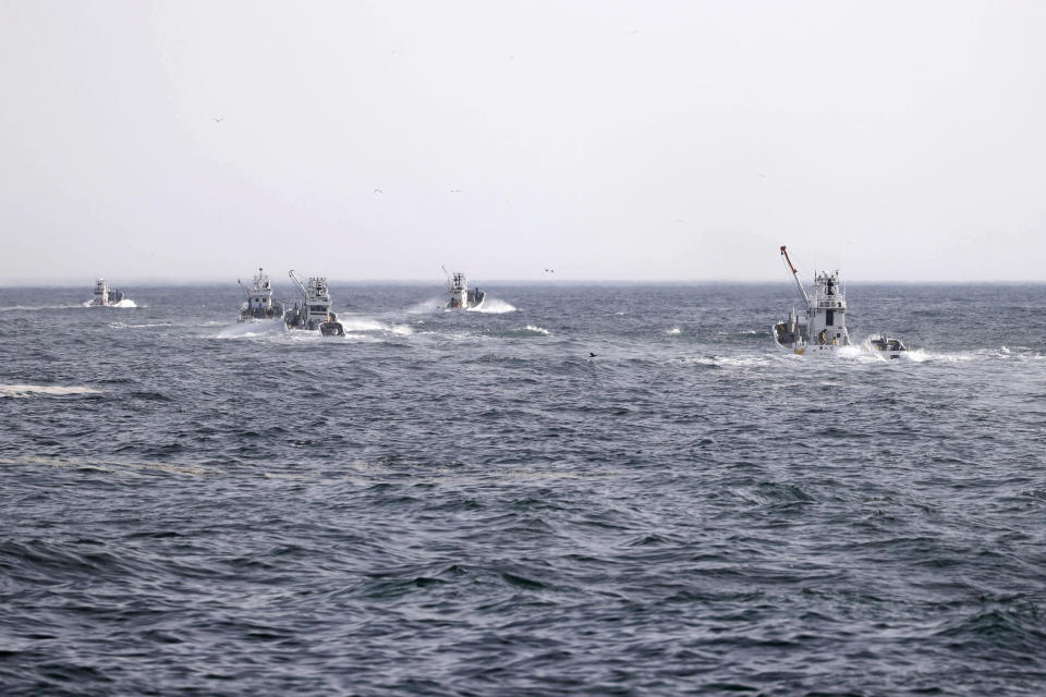 Fishing boats head to search for a missing tour boat off a port in Shari, in the northern island of Hokkaido Sunday, April 24, 2022. The Japanese Coast Guard said Sunday that rescue helicopters found four of the 26 people on a tour boat missing in the frigid waters of northern Japan since the day before, but their conditions are unknown. (Kyodo News via AP)