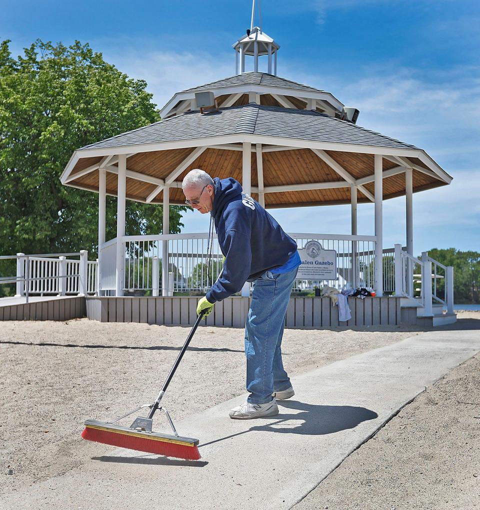 Dan Picewick sweeps the walkways at Sunset Lake in Braintree at the Whalen Gazebo.