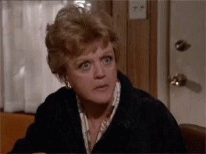 Angela Lansbury eating popcorn and leaning in in interest