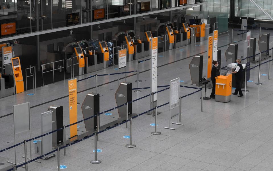 Employees stand in front of empty counters in a terminal of the Franz-Josef-Strauss airport in Munich - CHRISTOF STACHE/AFP