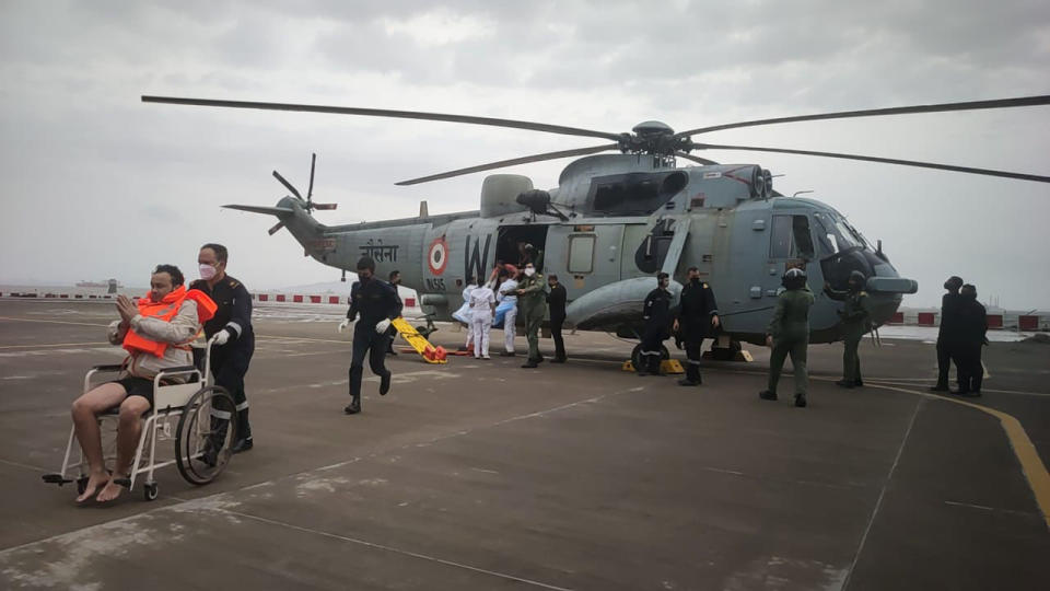 This photograph provided by Indian navy shows, one of the men rescued by the navy from the Arabian sea being brought for medical attention at naval air station INS Shikra in Mumbai, India, Tuesday, May 18, 2021. The Indian navy is working to rescue crew members from a sunken barge and a second cargo vessel that was adrift Tuesday off the coast of Mumbai after Cyclone Tauktae, struck the western coast. (Indian Navy via AP)