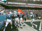 The Miami Dolphins celebrate with running back Kenyan Drake after he scored the winning touchdown during fourth quarter of an NFL football game against the New England Patriots Sunday, Dec. 9 2018, in Miami Gardens. The Dolphins won 34-33. (David Santiago/Miami Herald via AP)