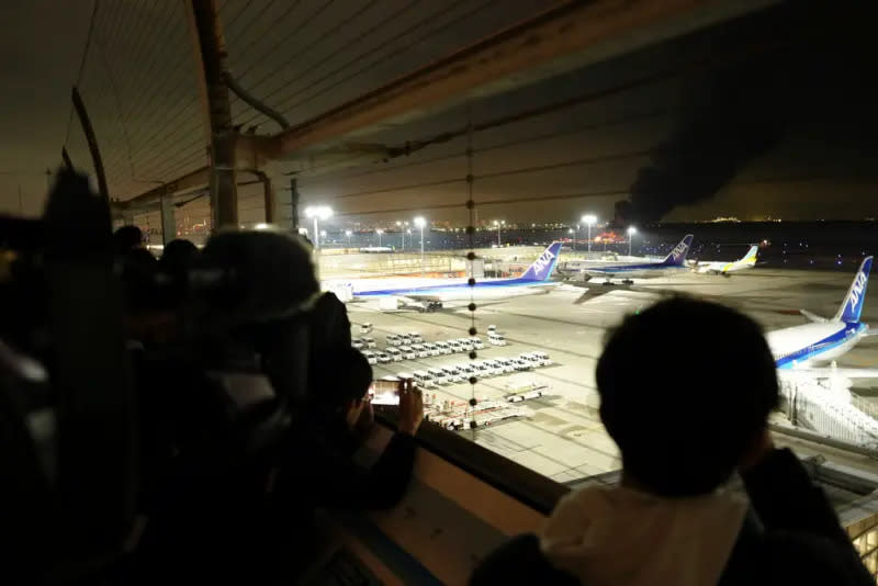 ▲日本東京羽田機場2日傍晚發生起火意外，目擊者在機場內可以看見不遠處起火的客機。（圖／美聯社 ／達志影像）