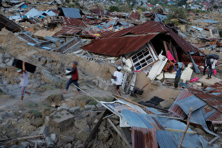 Residents carry their belongings after an earthquake hit at Balaroa sub-district in Palu, Sulawesi Island, Indonesia October 1, 2018. REUTERS/Beawiharta