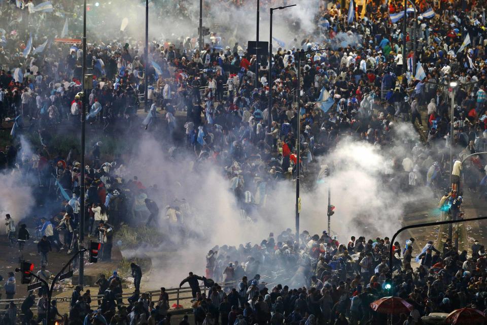 Argentina's fans run away from tear gas as they clash with riot police in Buenos Aires after Argentina lost to Germany in their 2014 World Cup final soccer match in Brazil, July 13, 2014. (REUTERS/Ivan Alvarado)