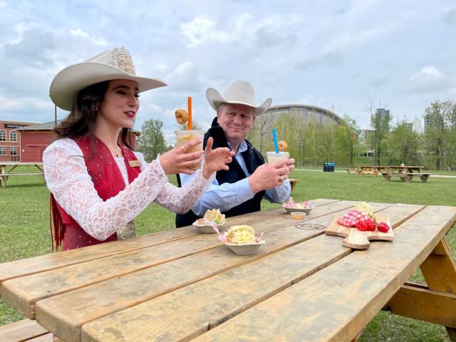 Stampede Princess Sarah Lambros, left, and Stampede CEO Joel Cowley taste the mini-donut boba lemonade, one of the more unusual food offerings this year. (Evelyne Asselin/CBC - image credit)