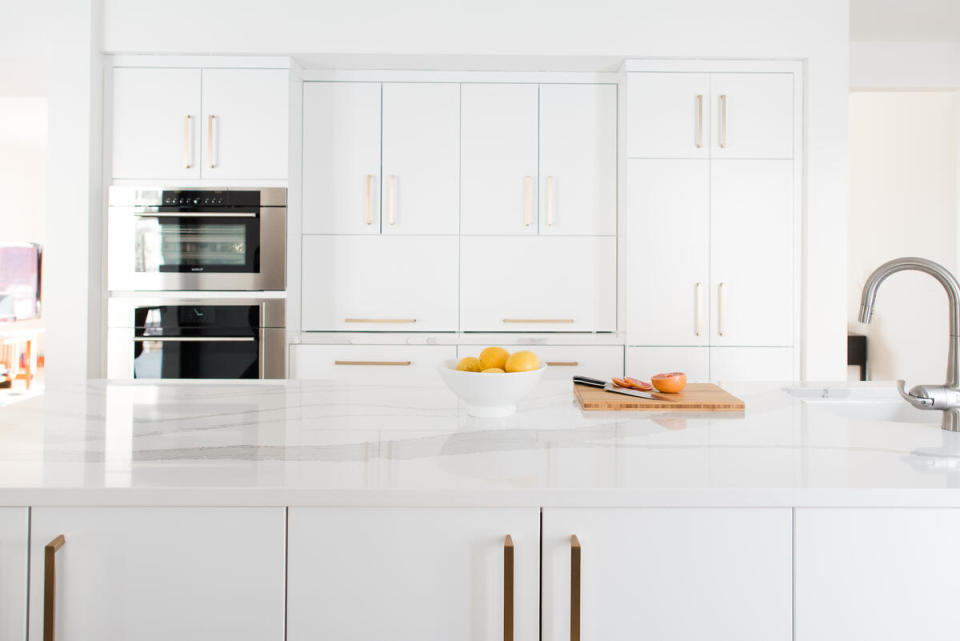 In a streamlined white kitchen, abundant cabinetry means that everything can be tucked out of sight