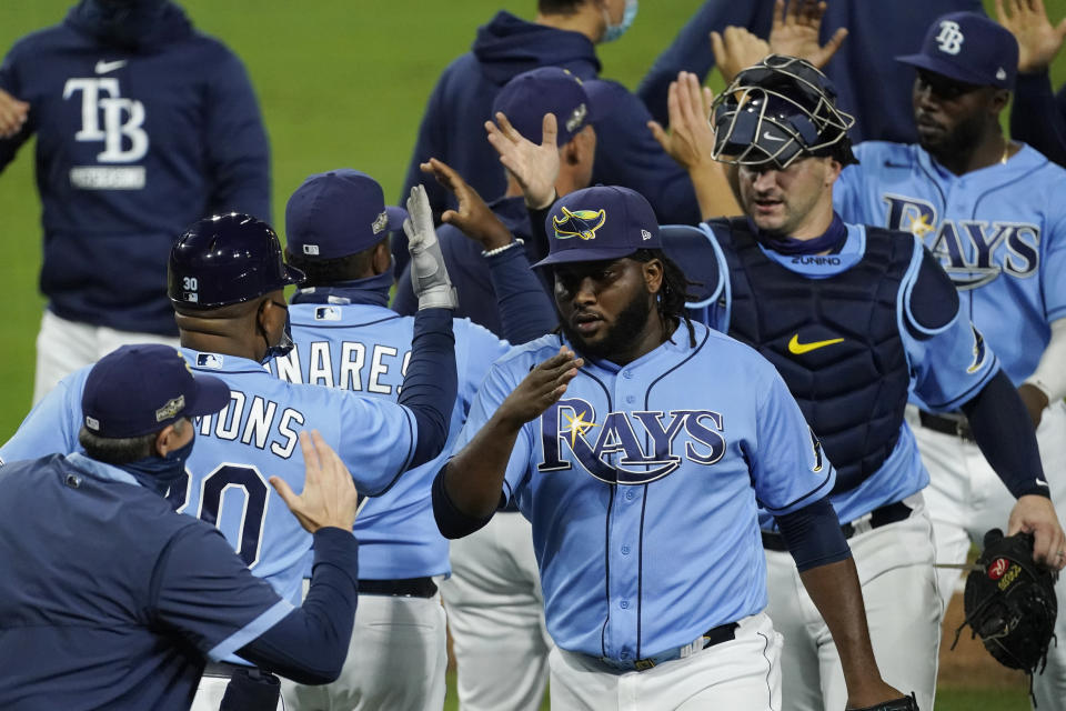 Tampa Bay Rays relief pitcher Diego Castillo, third right and catcher Mike Zunino, second right, celebrate their victory against Houston Astros in Game 1 of a baseball American League Championship Series, Sunday, Oct. 11, 2020, in San Diego. The Rays defeated the Astros 2-1 to lead the series 1-0 games.(AP Photo/Ashley Landis)