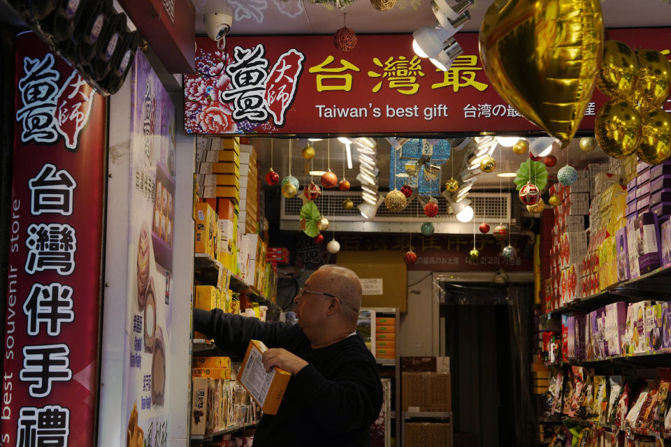 A vendor arrange boxes of pineapple tarts at a shop selling Taiwanese snacks in Taipei, Taiwan, Thursday, Jan. 11, 2024. Beijing's threats to use force to claim self-governed Taiwan aren't just about missiles and warships. Hard economic realities will be at play as voters head to the polls on Saturday, though the relationship is complicated. (AP Photo/Ng Han Guan)