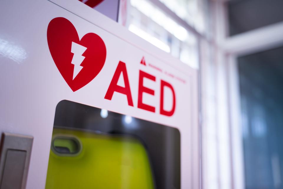 An automated external defibrillator (AED) analyzes heart rhythm and delivers an electric shock to restore normal rhythm, if needed.