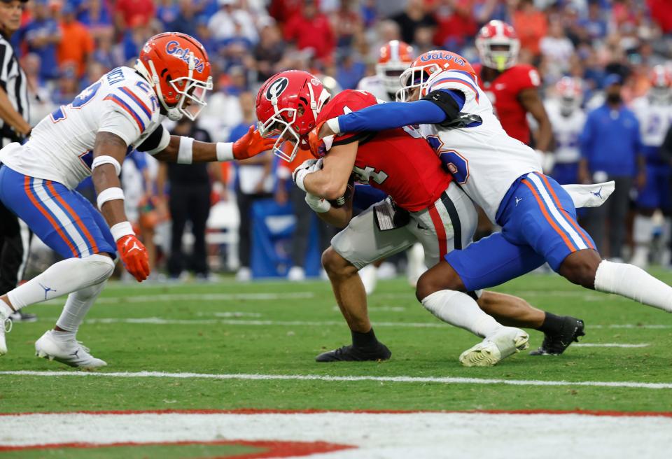Georgia wide receiver Ladd McConkey (84) runs the ball in for a touchdown as Florida safety Tre'Vez Johnson (16) attempted to defend during the second quarter at TIAA Bank Field.