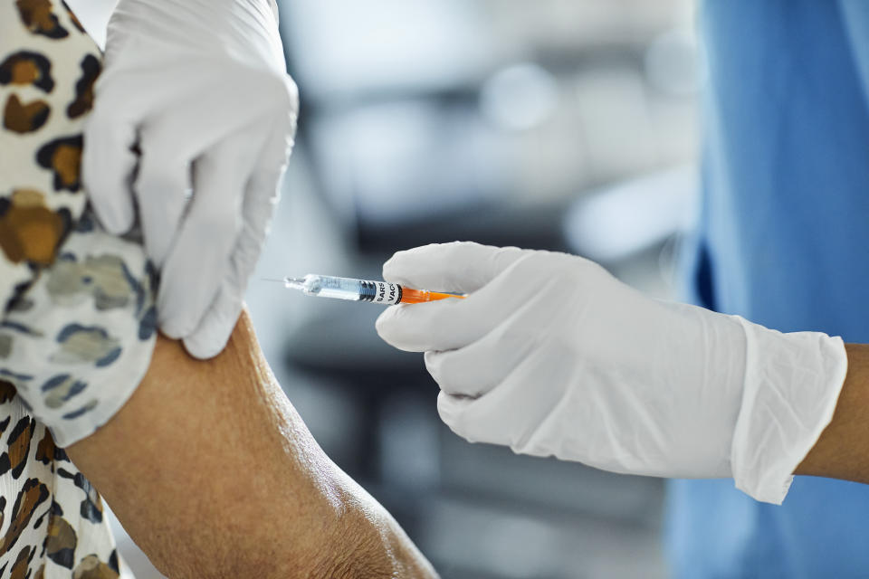 Cropped image of nurse injecting Covid-19 vaccine to a patient. Female health care worker is working at hospital. She is holding syringe.