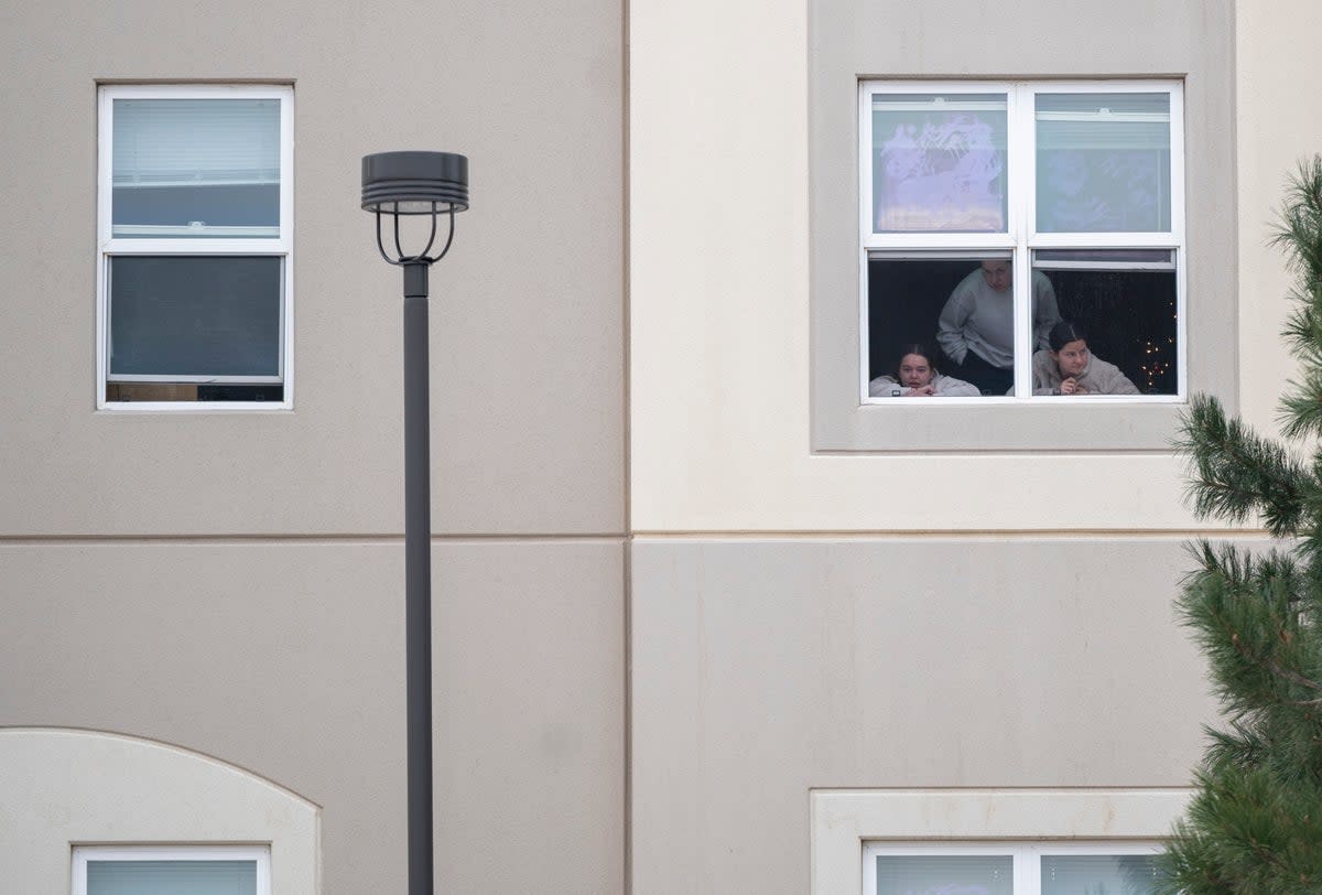 Students look outside their dorm window in the Village at Alpine Valley housing, as police investigate a shooting on the University of Colorado Colorado Springs campus (no sales mags out)