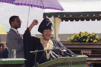 <p>Winnie Mandela, left, estranged wife of Nelson Mandela, salutes supporters while attending a funeral for a slain civic leader on, March 11, 1995 in Tembisa, South Africa. Embroiled in a corruption scandal that may cost her cabinet post, Winnie Mandela said she had not fought against apartheid to be treated as a criminal. Mrs. Mandela was attending the funeral of a squatter camp leader shot last week after voicing support for her in a television interview. (Photo: John Moore/AP) </p>