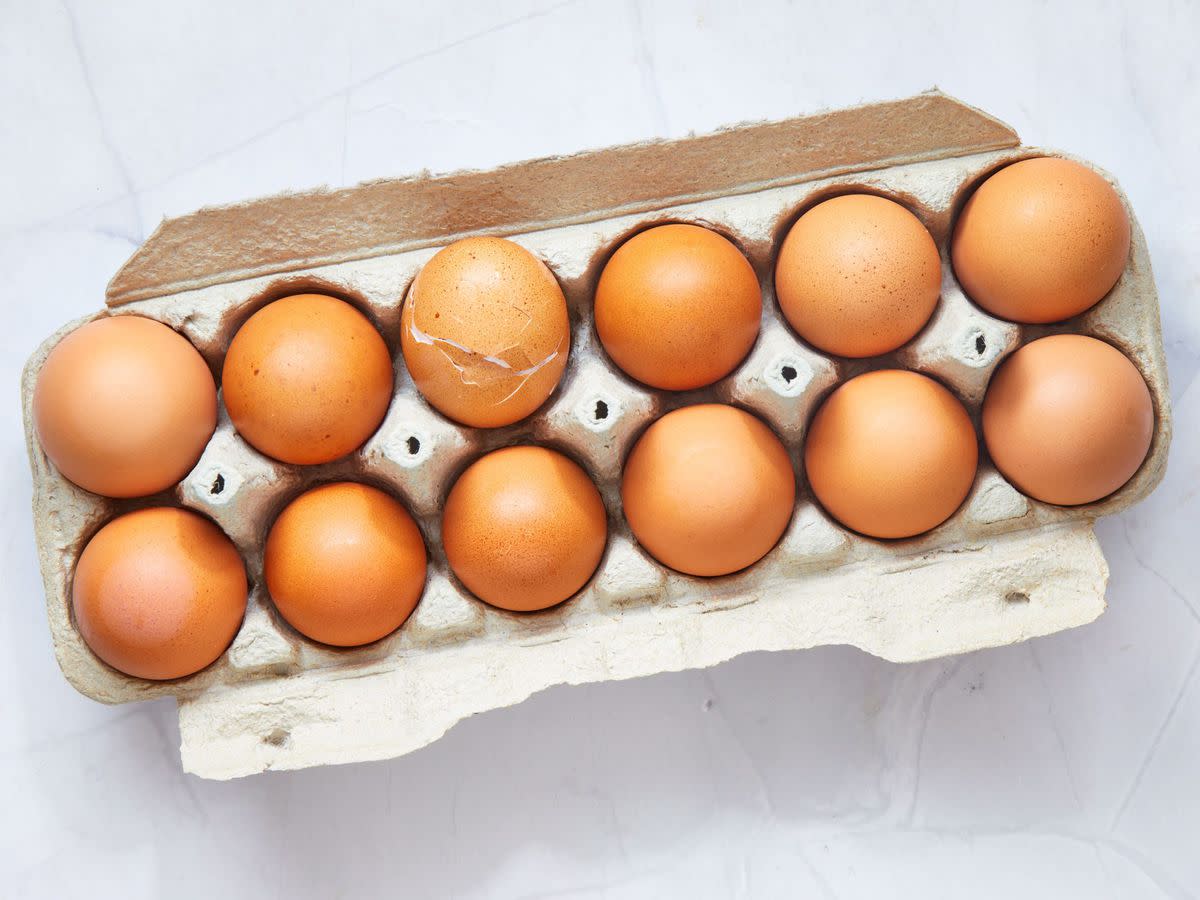 dozen eggs with one egg crackd
