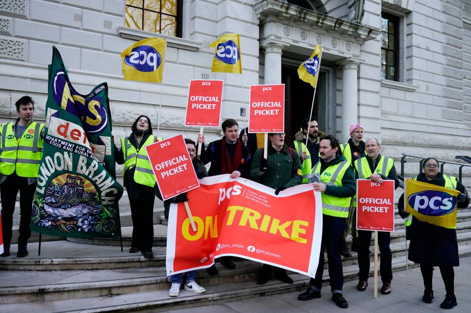 Members of the PCS union on the picket line outside the office of HM Treasury, in Westminster (PA)