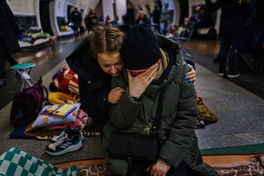 KYIV, UKRAINE -- MARCH 2, 2022: Anastasia Vakulenko, left, consoles Natalya Chikonova, right, as she breaks down talking about her worries and the war that is raging above ground, while they seek shelter underground in a subway station on the seventh day of the Russian invasion, in Kyiv, Ukraine, Wednesday, March 2, 2022. (MARCUS YAM / LOS ANGELES TIMES)