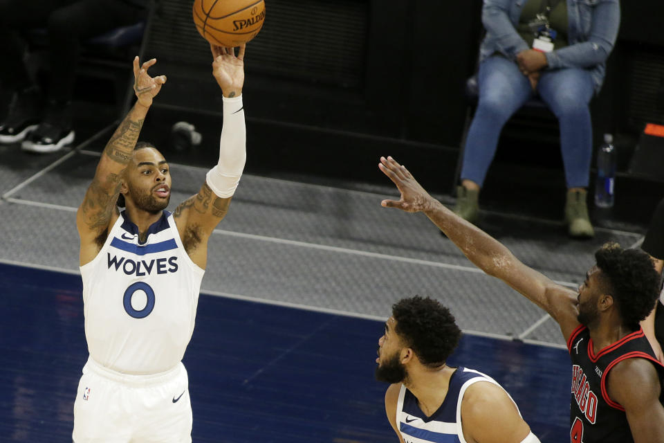 Minnesota Timberwolves guard D'Angelo Russell, left, shoots over Chicago Bulls forward Patrick Williams, right, with a pick from teammate Karl-Anthony Towns, center, in the second quarter during an NBA basketball game, Sunday, April 11, 2021, in Minneapolis. (AP Photo/Andy Clayton-King)