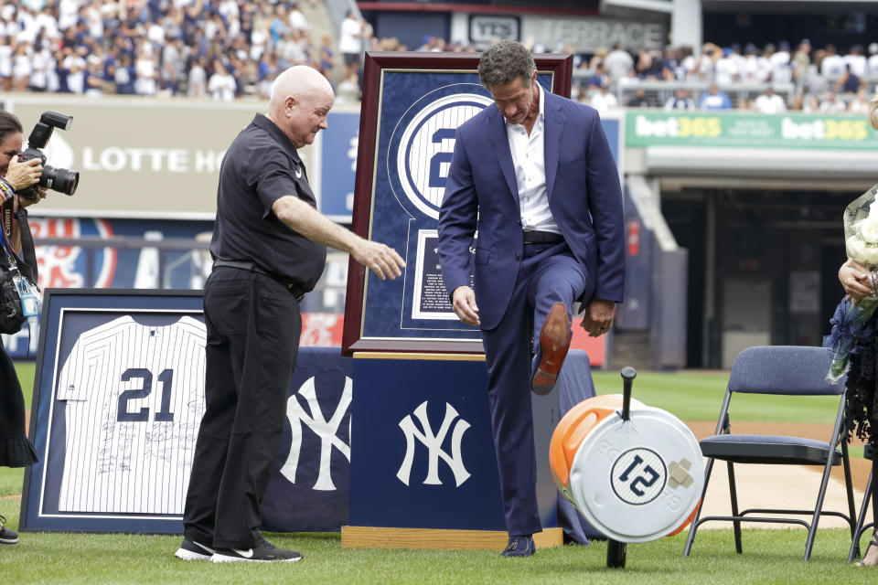 Retired New York Yankees player Paul O'Neill, right, kicks a water cooler he received as a gift as trainer Steve Donohue looks on during his number retirement ceremony before a baseball game between the Yankees and the Toronto Blue Jays, Sunday, Aug. 21, 2022, in New York. (AP Photo/Corey Sipkin)