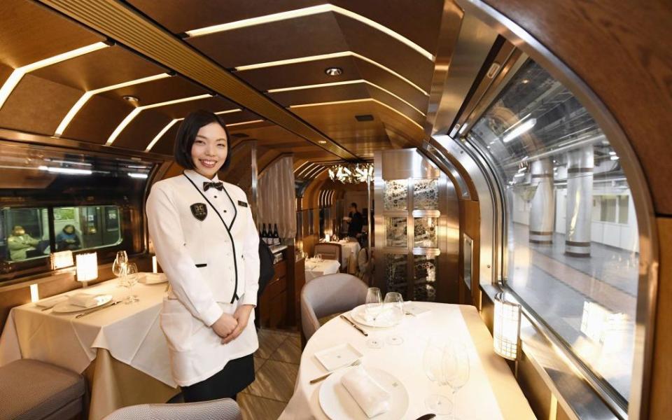 A waitress in the dining room of the newly unveiled Train Suite Shiki-Shima - Credit: Getty