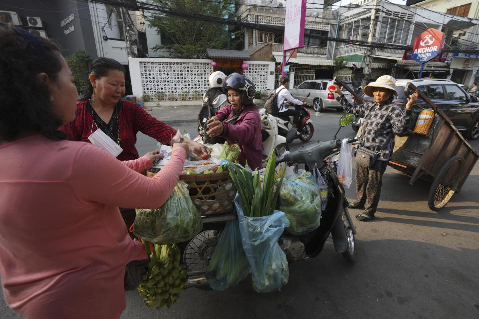 People buy fresh vegetables in front of VOD, Voice of Democracy, office in Phnom Penh Cambodia, Monday, Feb. 13, 2023. Cambodia's Prime Minister Hun Sen on Sunday, Feb. 12, ordered one of the handful of independent media broadcasters to shut down for publishing an article he said intentionally slandered his son in connection with the country's relief assistance to earthquake victims in Turkey. (AP Photo/Heng Sinith)