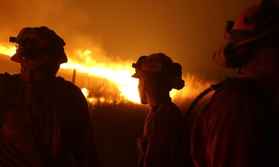 Incarcerated firefighters stand guard as flames from the Butte fire approach a containment line near San Andreas, California, in 2015.