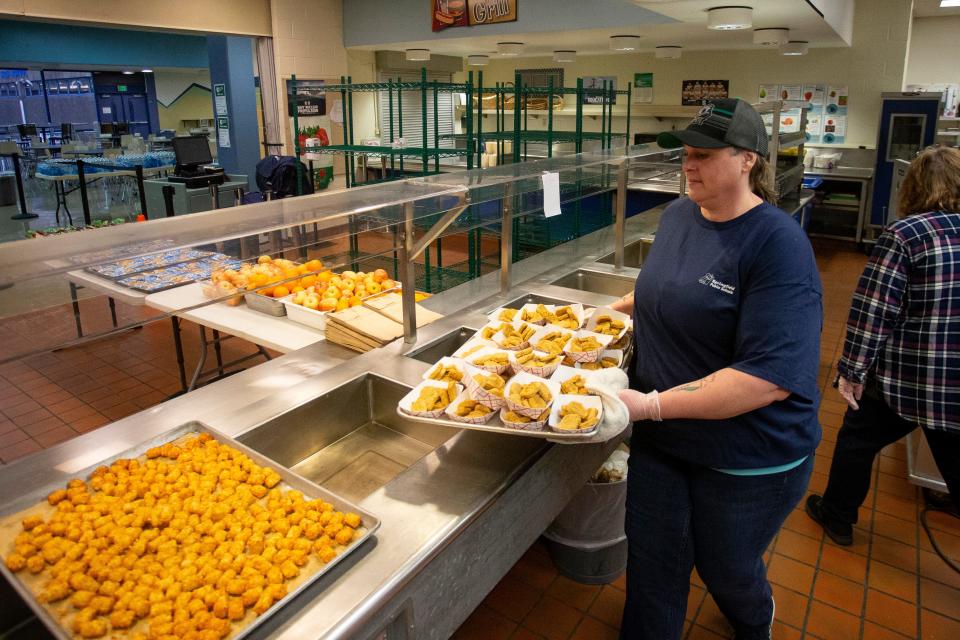 Alyssa Fickes organizes food before opening a respite center at Springfield High School as winter storm recovery gets underway Thursday, Jan. 18, 2024, in Springfield, Ore.