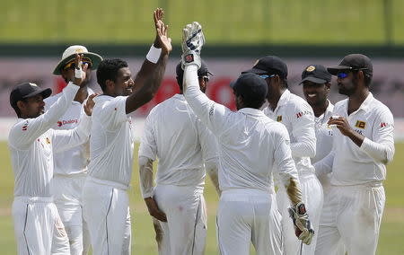 Sri Lanka's Dhammika Prasad (3rd L) celebrates with his teammates after taking the wicket of India's Ravichandran Ashwin (not pictured) during the second day of their third and final test cricket match in Colombo , August 29, 2015. REUTERS/Dinuka Liyanawatte