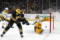 Boston Bruins' Mike Reilly backhands a shot past Nashville Predators goaltender Juuse Saros for a goal during the first period of an NHL hockey game Saturday, Jan. 15, 2022, in Boston. (AP Photo/Winslow Townson)
