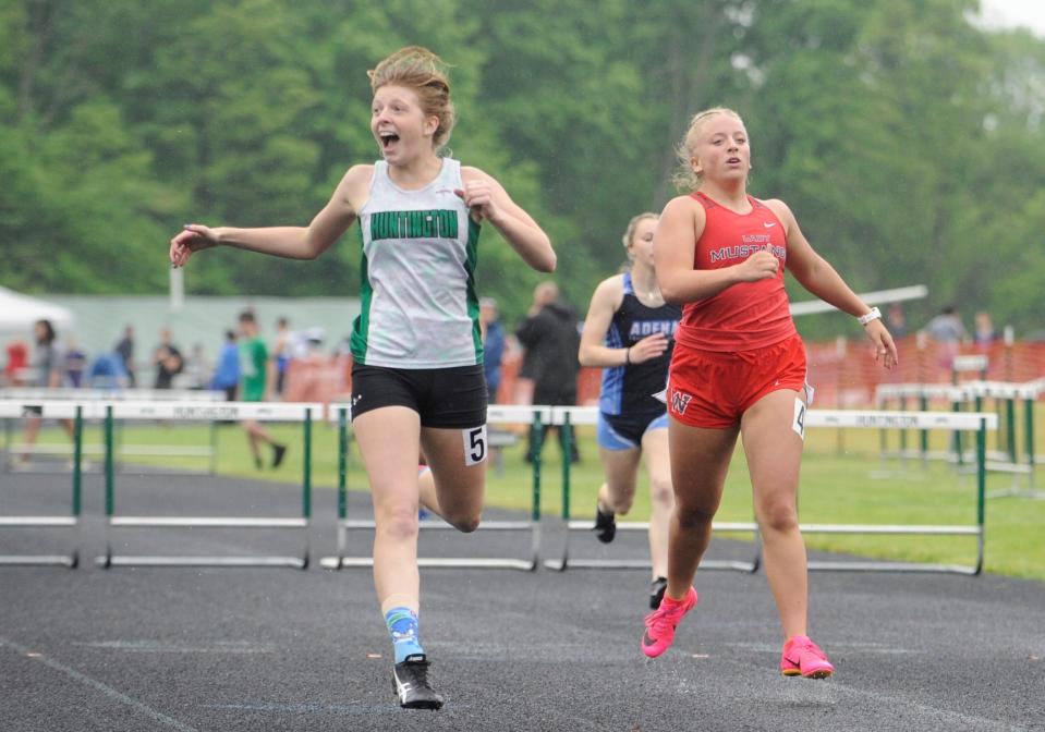 Huntington's Arlene Duty (left) celebrates after winning the girls 300m hurdles in the Scioto Valley Conference track and field championships at Huntington High School on May 12, 2023.